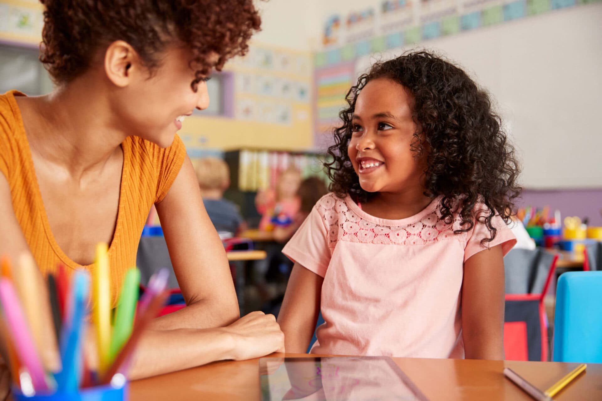 A teacher and a child smiling at each other in a Virginia Early Learning Academies classroom